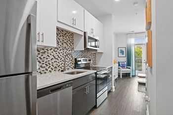 A kitchen with stainless steel appliances and white cabinets